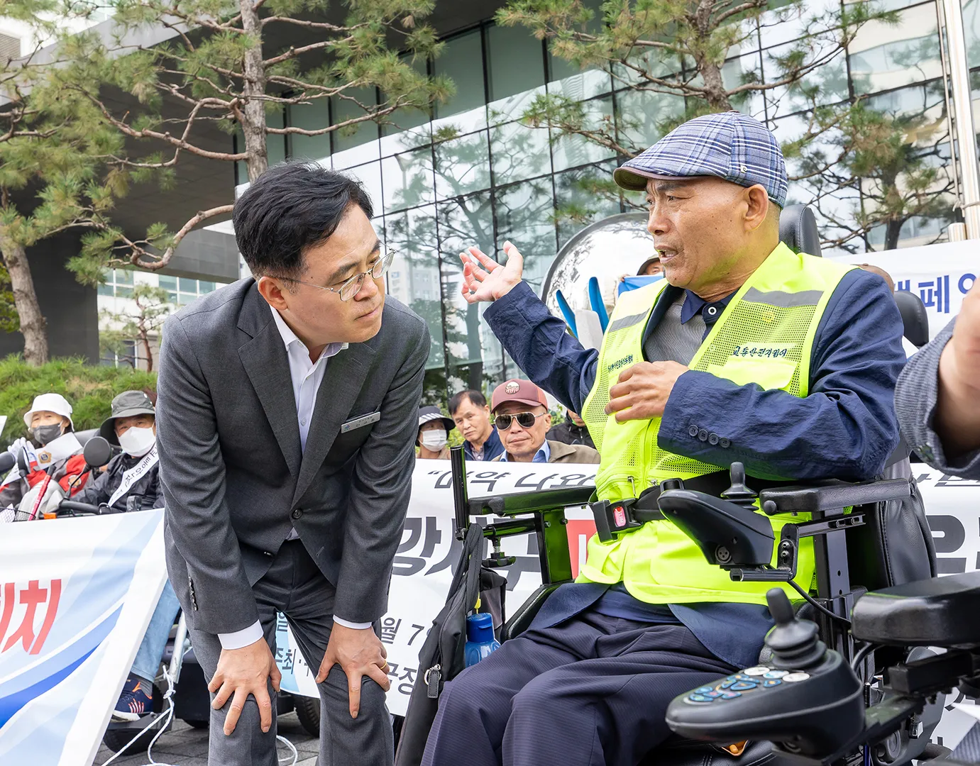 진교훈 ﻿구청장이 장애인 관련 행사를 찾아 허리를 굽혀 주민의 이야기를 듣고 있다.