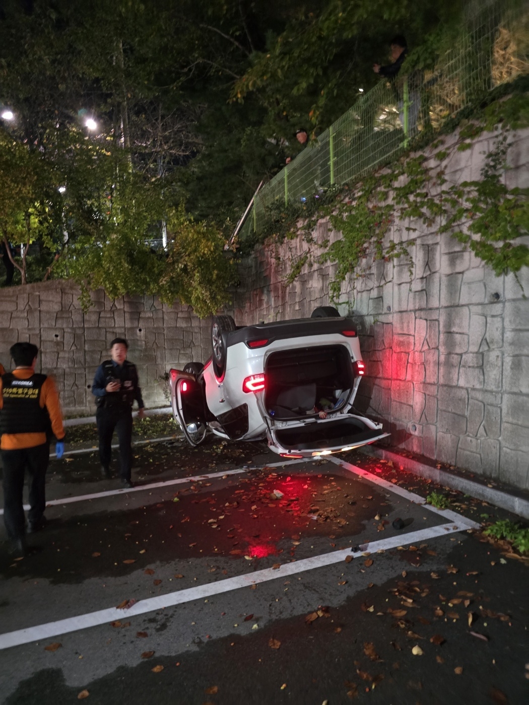 지난 15일 밤 울산경찰청 담장을 뚫고 추락한 SUV를 경찰관과 출동한 119구급대원이 살펴보고 있다. 울산경찰청 제공