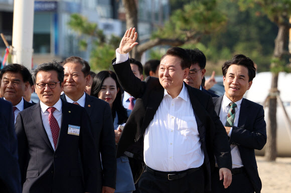 윤석열 대통령이 17일 오후 강원도 강릉시 강문해변을 찾아 이동하며 시민들을 향해 인사하고 있다. 2024.10.17. 대통령실 제공