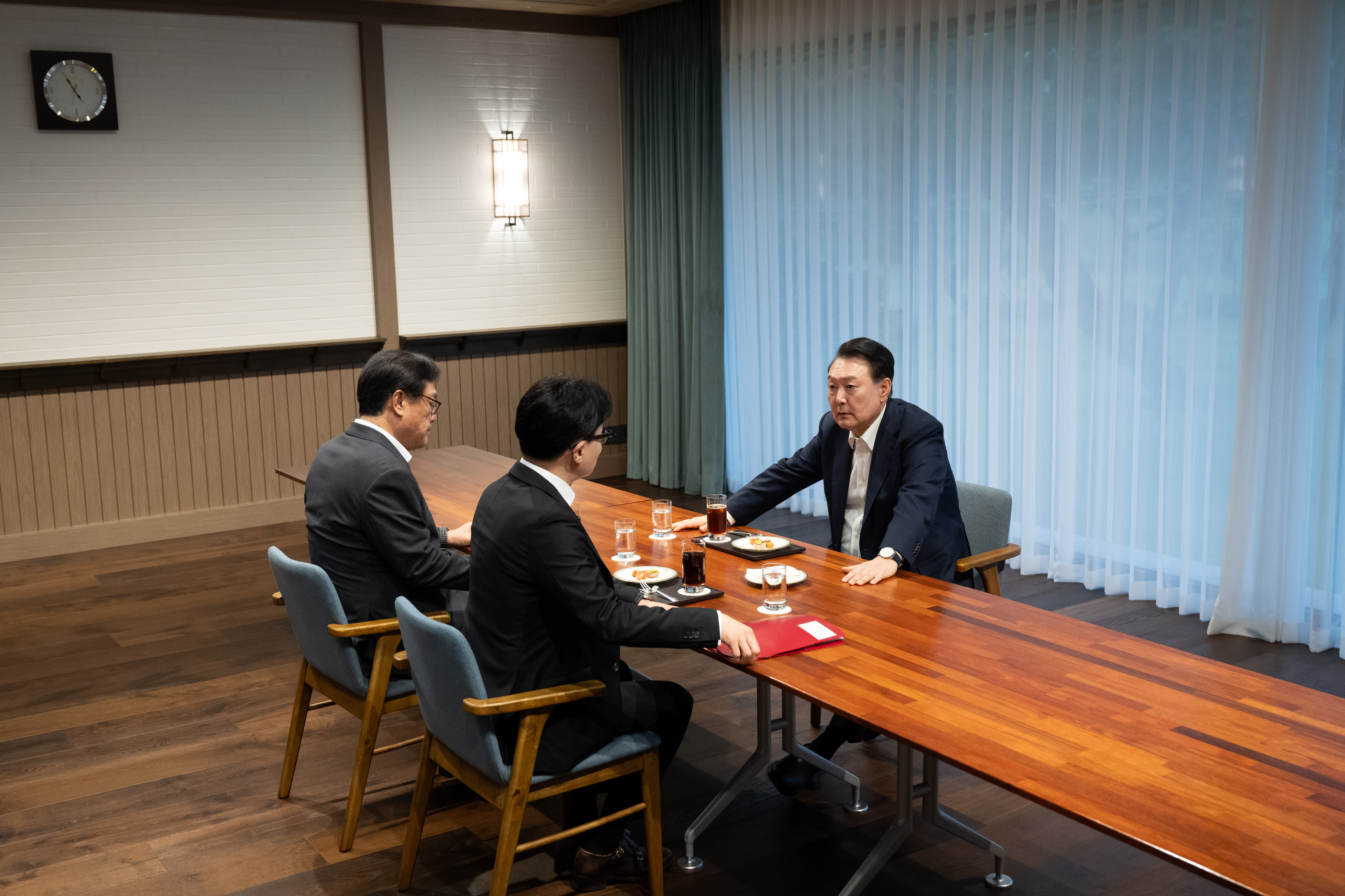 윤석열 대통령이 21일 서울 용산 대통령실 앞 파인그라스에서 국민의힘 한동훈 대표를 만나 대화하고 있다. 이 자리에는 정진석 대통령 비서실장이 배석했다.   대통령실 제공