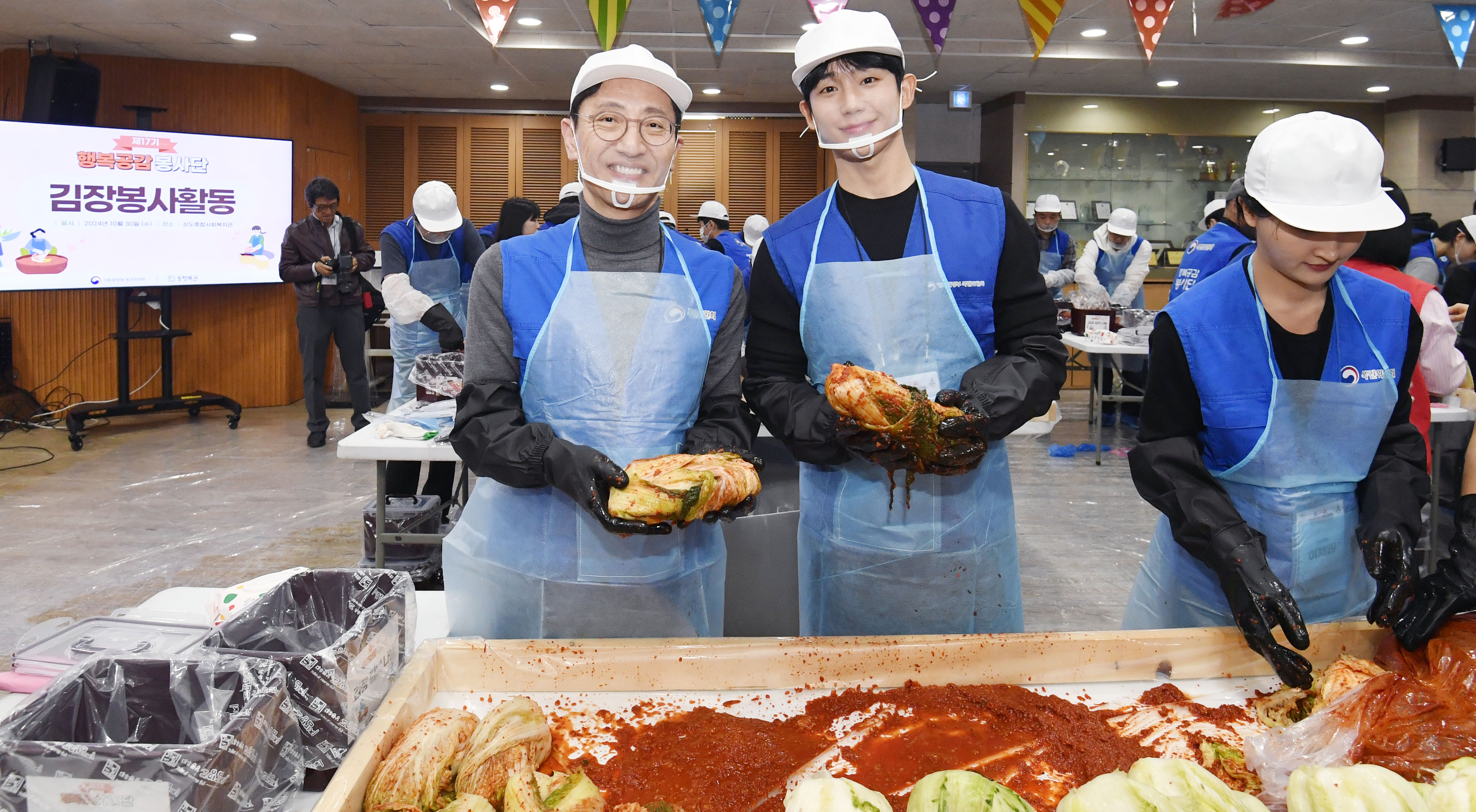 김윤상(왼쪽) 기획재정부 2차관과 배우 정해인(가운데)이 30일 서울 동작구 상도종합사회복지관에서 김장 봉사활동을 하고 있다. 기획재정부 제공