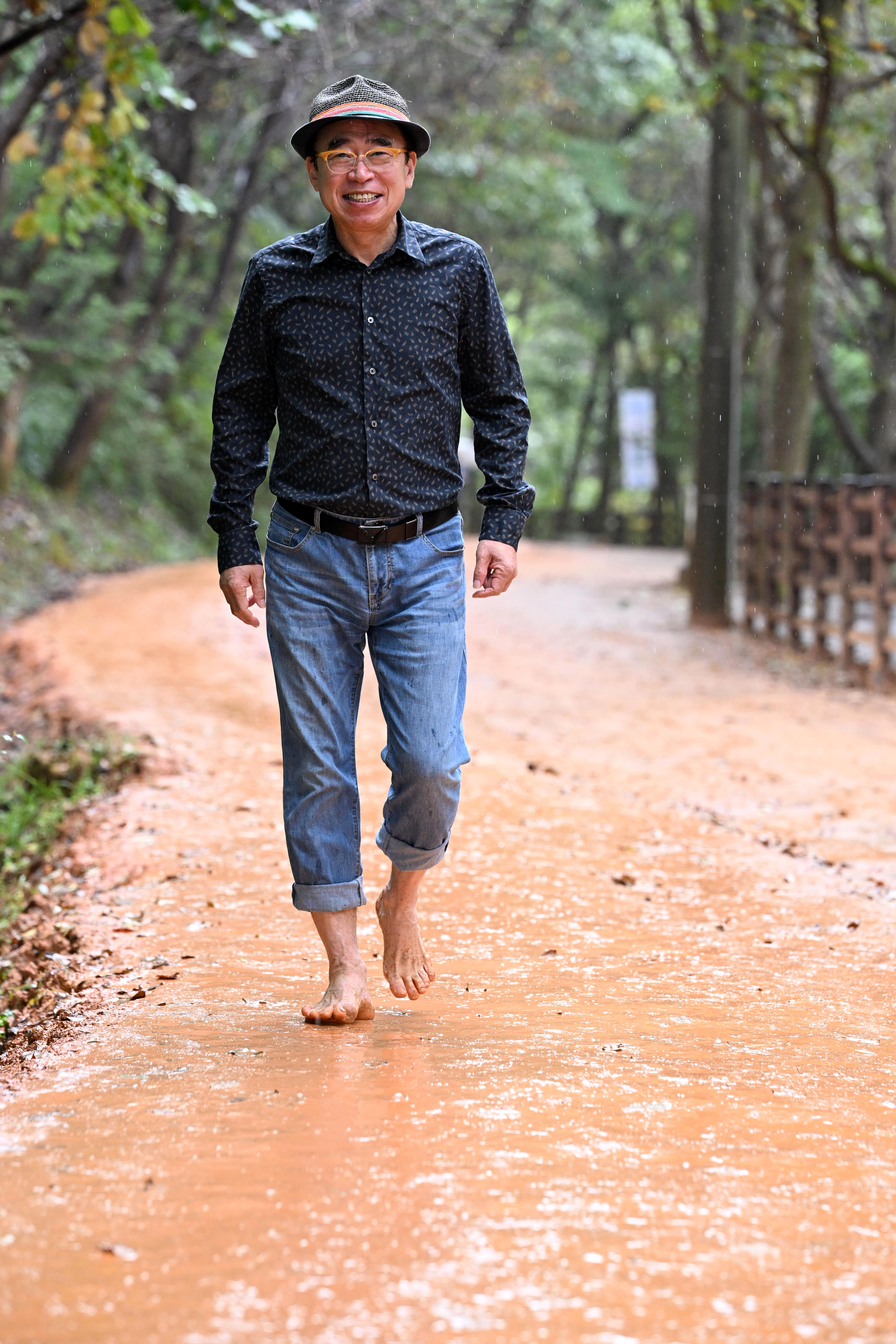 지난달 14일 대전 계족산 황톳길에서 조웅래 선양소주 회장이 맨발로 걸으며 환하게 웃고 있다. ‘황톳길 작업반장’을 자처하는 조 회장은 맨발 걷기의 매력에 빠져 2006년 계족산 임도에 황톳길을 조성하기 시작해 20여년째 이곳을 관리하고 있다. 대전 도준석 전문기자