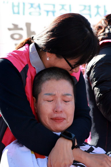 민주노총 서비스연맹 전국학교비정규직노동조합 조합원들이 6일 오전 서울 용산구 대통령실 인근에서 정부의 비정규직 임금 격차·학교급식실 결원·노동자 안전권 방치 등을 규탄하며 삭발식을 연 가운데 한 조합원이 삭발식에 참석한 조합원을 위로하고 있다. 2024.11.6 연합뉴스