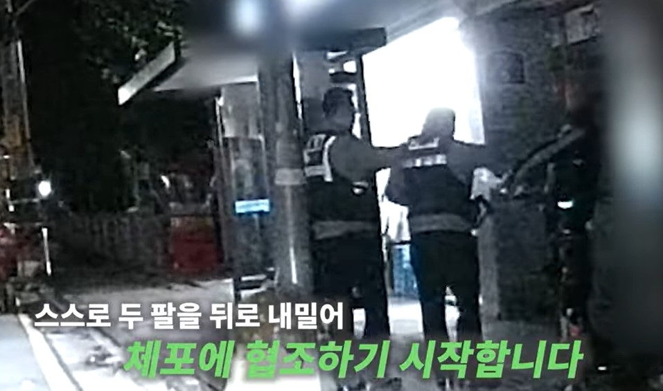 울산 북구의 한 편의점에서 낫을 꺼내 직원을 위협한 한 30대 남성이 두 팔을 뒤로 내밀어 경찰의 체포에 순순히 응하고 있다. 유튜브 채널 ‘대한민국 경찰청’ 캡처