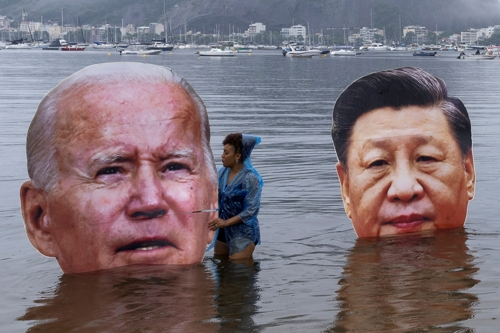 16일 브라질 리우데자네이루에서 열리는 G20 정상회의를 앞두고 원주민협회 회원들이 보타포고만 해상에서 조 바이든 미국 대통령과 시진핑 중국 주석의 대형 머리 조각을 들고 기후 변화에 대한 행동을 촉구하는 시위를 벌이고 있다. 리우데자네이루 로이터 연합뉴스