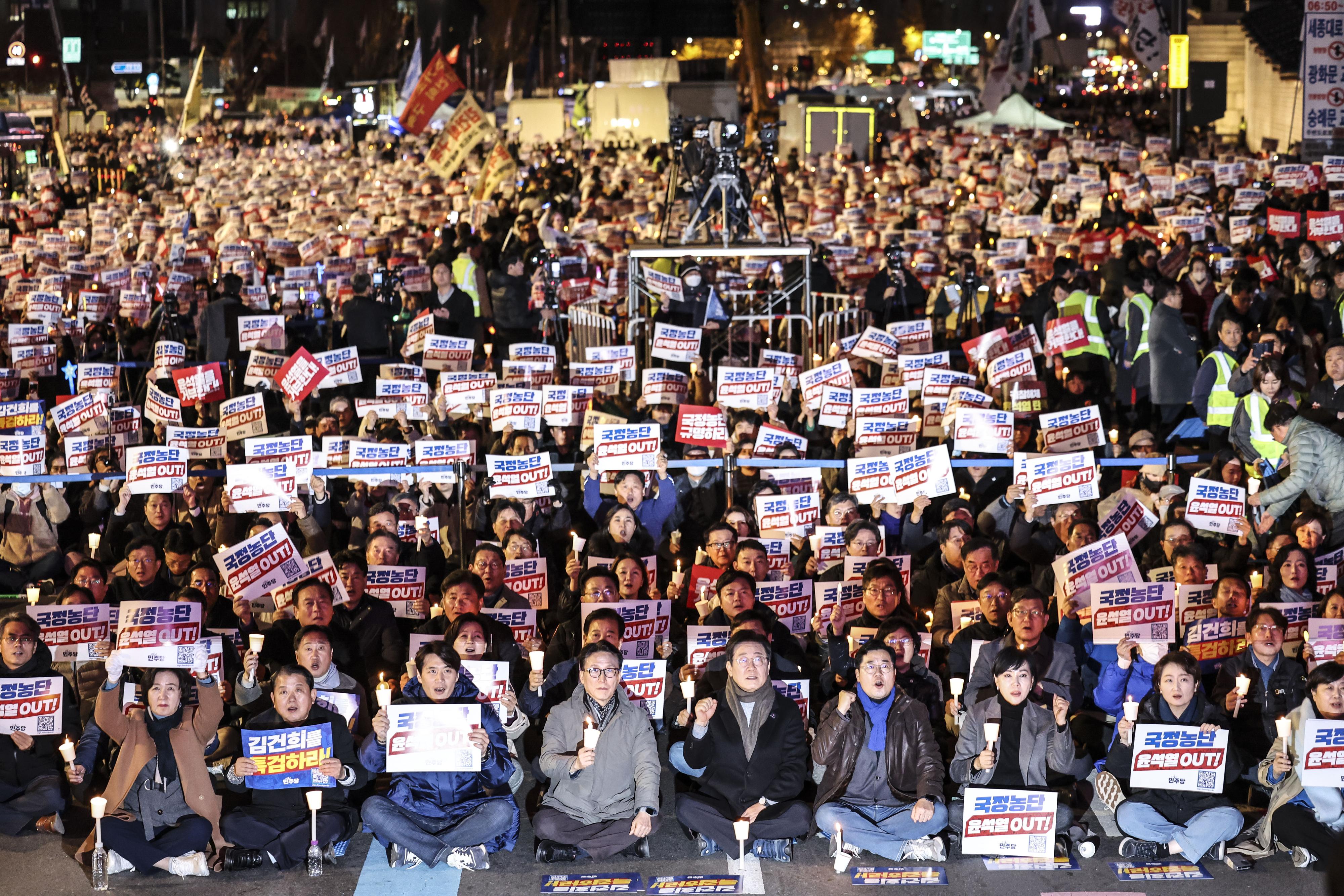 이재명(앞줄 오른쪽 다섯 번째) 더불어민주당 대표를 비롯한 야당 의원들이 지난 23일 서울 광화문광장에서 열린 집회에서 촛불과 피켓을 든 채 구호를 외치고 있다. 뉴시스