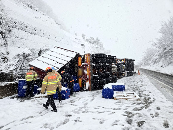 27일 대설 특보가 내려진 전북 진안군 진안읍 익산∼포항 고속도로에서 화학물질을 실은 트럭이 눈길에 미끄러져 뒤집혀 있다. 2024.11.27  전북특별자치도 소방본부 제공