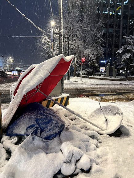 서울 등 중부 지역에 많은 눈이 내린 27일 오전 서울 종로 한 거리 위 우산 등에 눈이 쌓여 있다. 2024.11.27  연합뉴스