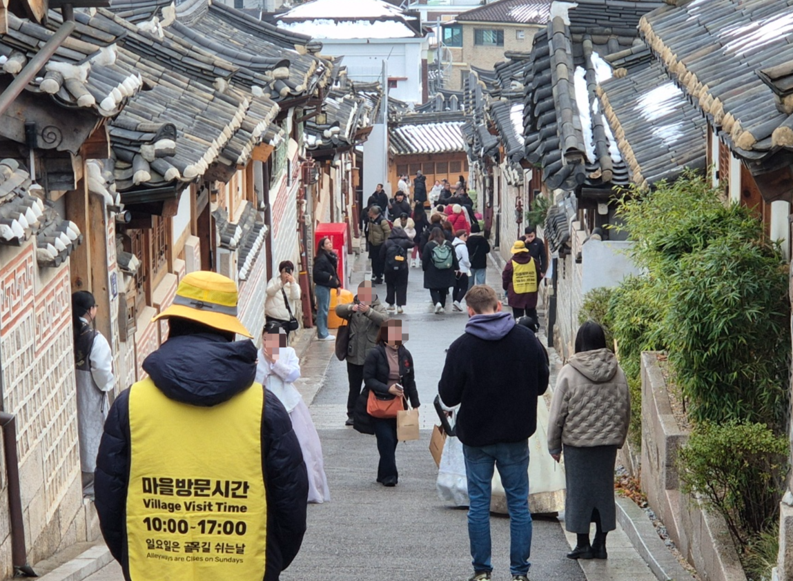 지난 1일 ‘레드존’으로 지정된 지 한 달을 맞은 서울 종로구 북촌한옥마을 일대에 계도요원이 서 있다. 이들은 마을 방문 시간이 적힌 노란 조끼를 입고 관광객 출입을 통제하거나 소음을 관리한다.