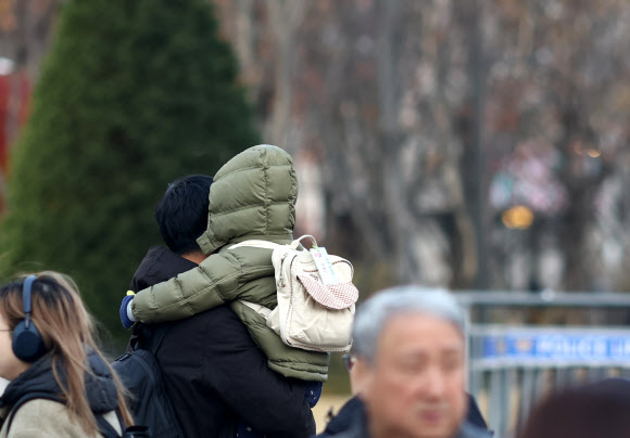 아침 영하권 추위를 보인 3일 서울 세종대로 사거리에서 한 어린이가 아빠에 안겨 길을 건너고 있다. 2024.12.3  연합뉴스