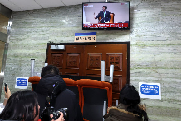윤석열 대통령이 3일 밤 긴급성명을 통해 비상계엄을 선포한 가운데 4일 새벽 서울 영등포구 여의도 국회 본회의장 앞에서 관계자들이 비상계엄 해제 요구 결의안 가결 모습을 지켜보고 있다. 2024.12.4. 연합뉴스