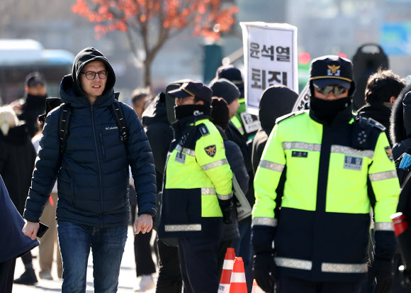 윤석열 대통령이 긴급 대국민 담화를 통해 비상계엄 해제를 선언한 4일 오전 서울 종로구 광화문광장에서 한 외국인 관광객이 계엄 규탄 집회를 지켜보고 있다. 2024.12.4. 연합뉴스