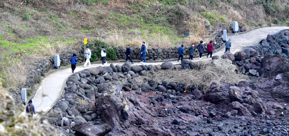 흐린 날씨를 보인 5일 오전 제주시 애월읍 한담해변을 찾은 관광객이 산책하고 있다. 2024.12.5  연합뉴스