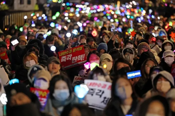 8일 오후 서울 여의도 국회 앞에서 열린 윤석열 탄핵 및 구속을 촉구하는 촛불문화제에서 참가자들이 관련 손팻말과 응원봉을 들고 있다. 2024.12.8