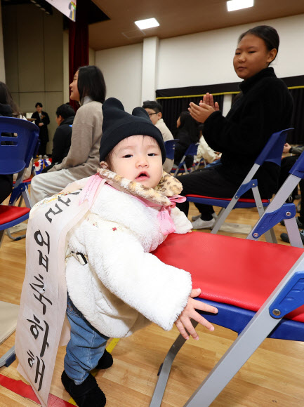 13일 오전 인천 남동구 남촌초등학교에서 열린 제 ‘23회 졸업장 수여식’에서 한 어린이가 언니의 졸업을 축하해주고 있다. 2024.12.13  연합뉴스