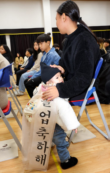 13일 오전 인천 남동구 남촌초등학교에서 열린 제 ‘23회 졸업장 수여식’에서 한 어린이가 언니의 졸업을 축하해주고 있다. 2024.12.13  연합뉴스