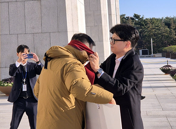 14일 오전 국민의힘 한동훈 대표가 국회 본청 앞에서 탄핵 찬성을 촉구하며 1인 시위를 하던 국민의힘 김상욱 의원에게 다가가 자기 목에 두르고 있던 빨간색 목도리를 풀어 김 의원에게 둘러주고 있다. 2024.12.14. 김상욱 의원실 제공