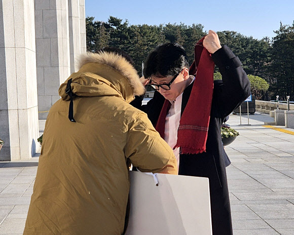 14일 오전 국민의힘 한동훈 대표가 국회 본청 앞에서 탄핵 찬성을 촉구하며 1인 시위를 하던 국민의힘 김상욱 의원에게 다가가 자기 목에 두르고 있던 빨간색 목도리를 풀어 김 의원에게 둘러주고 있다. 2024.12.14. 김상욱 의원실 제공