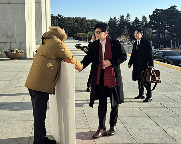 14일 오전 국민의힘 한동훈 대표가 국회 본청 앞에서 탄핵 찬성을 촉구하며 1인 시위를 하던 국민의힘 김상욱 의원에게 다가가 악수를 청하고 있다. 2024.12.14. 김상욱 의원실 제공