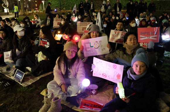 13일(현지시간) 저녁 영국 런던에서 윤석열 대통령 퇴진을 촉구하는 집회가 열리고 있다. 이날 집회에는 교민과 유학생 등 약 300명이 야광봉, 촛불 등을 들고 참여했다. 2024.12.14. 연합뉴스