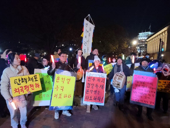 지난 13일(현지시간) 미국 워싱턴 DC에서 비상계엄 사태와 관련해 윤석열 대통령 탄핵을 촉구하는 교민들 집회가 열렸다.  ‘워싱턴촛불행동’ 주최로 열린 집회에 참석한 교민 50여 명은 백악관 앞 라파예트 공원에 모여 구호를 외치고 자유 발언을 하며 국회의 윤 대통령 탄핵안 가결을 촉구했다. 2024.12.14. 연합뉴스