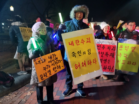 지난 13일(현지시간) 미국 워싱턴 DC에서 비상계엄 사태와 관련해 윤석열 대통령 탄핵을 촉구하는 교민들 집회가 열렸다.  ‘워싱턴촛불행동’ 주최로 열린 집회에 참석한 교민 50여 명은 백악관 앞 라파예트 공원에 모여 구호를 외치고 자유 발언을 하며 국회의 윤 대통령 탄핵안 가결을 촉구했다. 2024.12.14. 연합뉴스