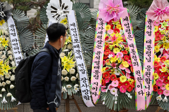 17일 오전 서울 종로구 헌법재판소 앞에 윤석열 대통령 지지 화환과 반대 화환(왼쪽)이 놓여 있다. 2024.12.17  연합뉴스