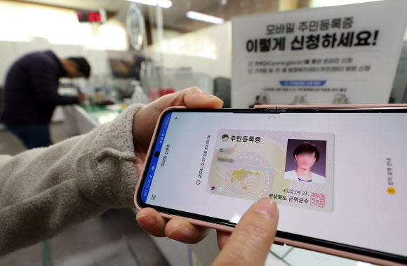 모바일 주민등록증 시범 발급이 시작된 27일 오전 대구 군위군 군위읍행정복지센터에서 시민들이 발급받은 모바일 주민등록증을 들어 보이고 있다. 행정안전부는 세종시, 강원 홍천군, 경기 고양시, 경남 거창군, 대전 서구, 대구 군위군, 울산 울주군, 전남 여수시, 전남 영암군 등 9개 지자체를 대상으로 모바일 주민등록증을 시범 발급한다. 2024.12.27 연합뉴스