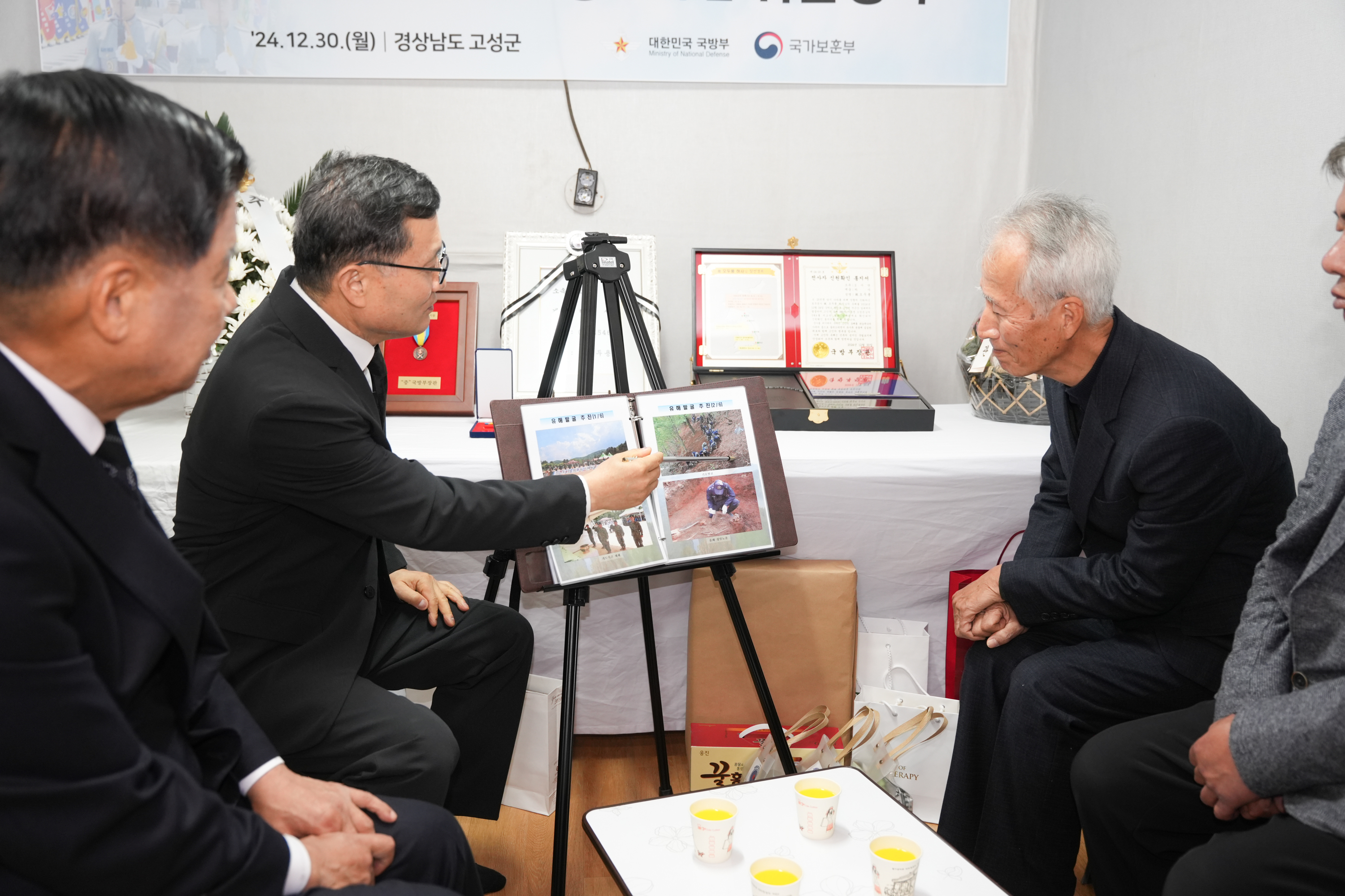 이근원(왼쪽) 국방부 유해발굴감식단장이 30일 경남 고성군에 있는 유가족 자택에서 고 오두용 하사의 ‘호국의 영웅 귀환 행사’를 갖고 유가족에게 고인의 참전 과정과 유해발굴 경과를 설명하고 있다. 국방부 유해발굴감식단 제공