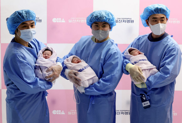 2025년 을사년(乙巳年) 새해 첫날인 1일 오전 경기도 고양시 일산차병원에서 아빠들이 갓 태어난 태명 딩굴이(오른쪽부터), 꼬물이, 니케를 품에 안고 있다. 2025.1.1. 연합뉴스