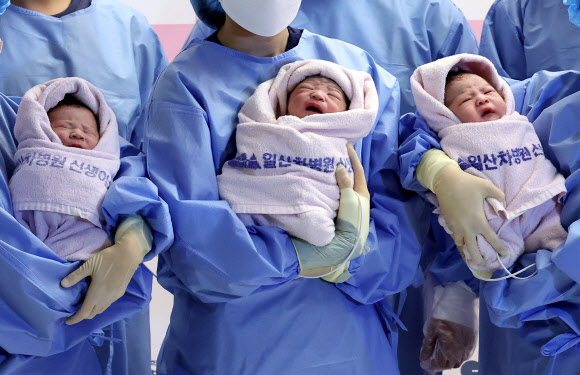2025년 을사년(乙巳年) 새해 첫날인 1일 오전 경기도 고양시 일산차병원에서 갓 태어난 태명 딩굴이(오른쪽부터), 꼬물이, 니케가 간호사들의 품에 안겨 있다.  2025.1.1. 연합뉴스