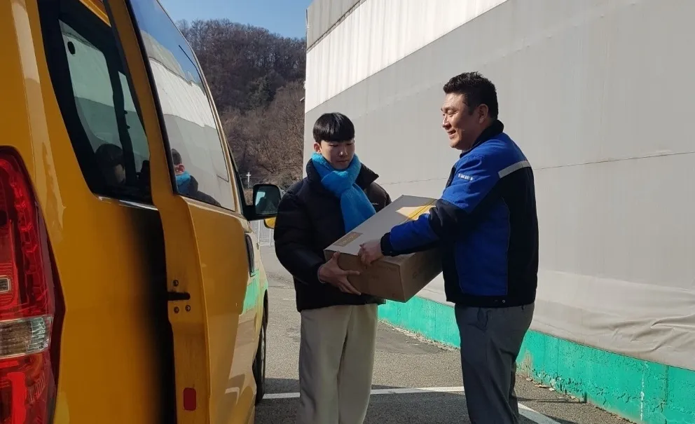 이상훈 ㈜주안홀딩스 대표(오른쪽)가 지역아동센터에 간식을 전달하고 있다. 지역아동센터 제공