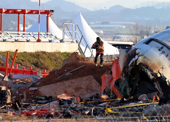 3일 오전 전남 무안군 무안국제공항 제주항공 여객기 사고 현장에서 소방 관계자가 잔해물을 촬영하고 있다. 2025.1.3 연합뉴스