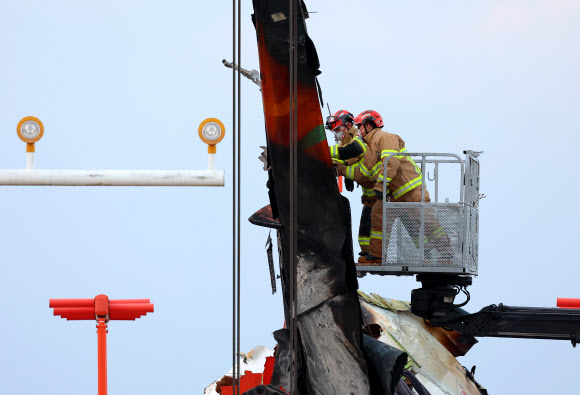 제주항공 여객기 참사 6일째인 3일 오후 전남 무안국제공항 사고 현장에서 119 소방대원이 크레인으로 바로세워진 꼬리날개 부분을 살피고 있다. 2025.1.3. 연합뉴스
