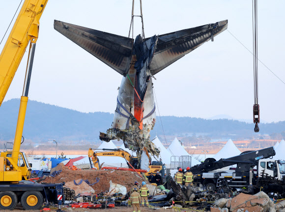 제주항공 여객기 참사 6일째인 3일 오후 전남 무안국제공항 사고 현장에서 수색당국이 꼬리날개 부분을 크레인으로 들어 옮기고 있다. 수색당국은 꼬리만 남은 기체를 옮긴 뒤 사고 현장 수색을 이어 나갈 예정이다. 2025.1.3. 연합뉴스