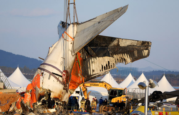 제주항공 여객기 참사 6일째인 3일 오후 전남 무안국제공항 사고 현장에서 당국이 꼬리날개 부분을 크레인 2대와 연결해 들어 올리고 있다. 2025.1.3. 연합뉴스