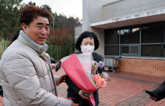 사건 발생 24년 만에 재심에서 무죄를 선고받은 김신혜 씨가 6일 전남 장흥군 용산면 장흥교도소에서 석방돼 ‘낙동강살인사건’으로 억울한 옥살이를 했던 장동익 씨로부터 꽃다발을 받고 있다. 김씨는 2000년 3월 아버지(당시 52세)에게 수면제를 탄 양주를 먹여 살해한 혐의로 기소돼 1심에서 무기징역을 선고받아 대법원 확정판결까지 받았으나, 2015년 재심 개시가 결정돼 이날 무죄를 선고받았다. 2025.1.6. 연합뉴스