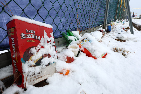 제주항공 여객기 참사 열흘째인 7일 전남 무안군 무안국제공항 사고 현장 울타리에 놓인 추모 물품이 흰 눈에 덮여 있다. 2025.1.7. 연합뉴스