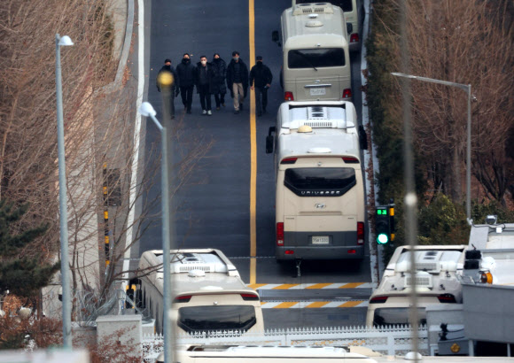 공수처와 경찰이 윤석열 대통령 2차 체포 영장 집행을 이번 주중에 시도할 것이라는 전망이 유력하게 거론되고 있는 가운데 12일 서울 용산구 한남동 대통령 관저 입구에서 경비인력으로 추정되는 사람들이 이동하고 있다. 2025.1.12  연합뉴스