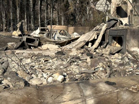 11일(현지시간) 미국 로스앤젤레스에서 대형 산불이 닷새째 확산 중인 가운데 이미 불길이 휩쓸고 간 알타데나 주택가의 피해 현장에 불에 탄 전자레인지, 차량 등의 모습이 보인다. 2025.1.12  연합뉴스