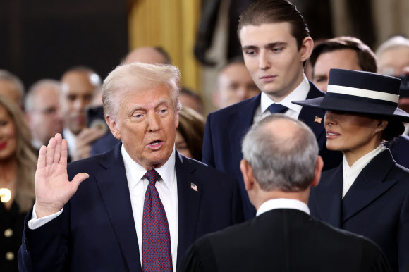 President-elect Donald Trump, from left, takes the oath of office as Barron Trump and Melania Trump watch at the 60th Presidential Inauguration in the Rotunda of the U.S. Capitol in Washington, Monday, Jan. 20, 2025. AP