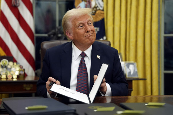 President Donald Trump signs executive orders in the Oval Office of the White House, Monday, Jan. 20, 2025, in Washington. AP 연합뉴스