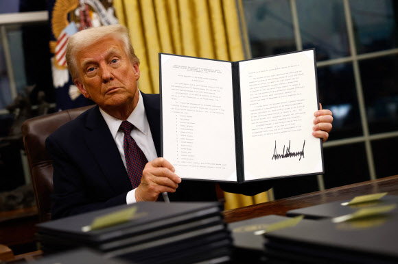 WASHINGTON, DC - JANUARY 20: President Donald Trump signs executive orders in the Oval Office on January 20, 2025 in Washington, DC. Trump takes office for his second term as the 47th president of the United States. 게티 AFP 연합뉴스