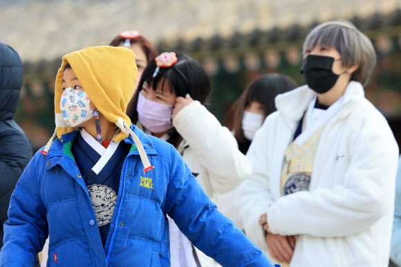 전국 대부분 지역에서 미세먼지 농도가 ‘나쁨’ 수준을 보인 22일 오후 서울 종로구 경복궁에서 마스크를 쓴 외국인 관광객들이 가이드 설명을 듣고 있다. 2025.1.22 연합뉴스