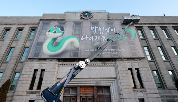 23일 서울 중구 서울도서관 외벽 대형 글판인 서울꿈새김판이 푸른 뱀의 해를 맞아 “막힘없이 나아가는 2025” 문구로 새로 꾸며지고 있다. 2025.1.23  연합뉴스