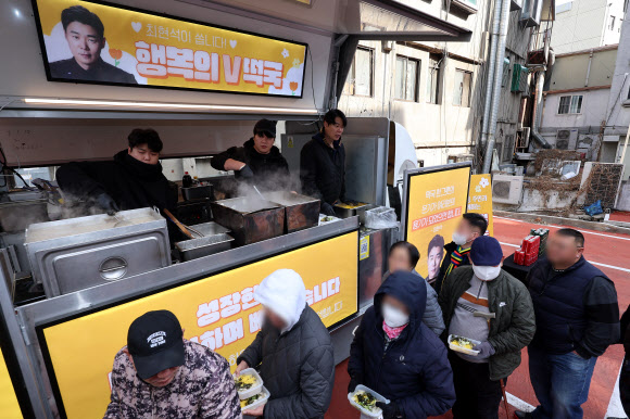 최현석 셰프가 설 연휴 둘째 날인 26일 오전 서울역 쪽방상담소 인근에서 열린 떡국 나눔 푸드트럭 행사에서 쪽방촌 주민들에게 떡국을 나눠주고 있다. 2025.1.26. 연합뉴스