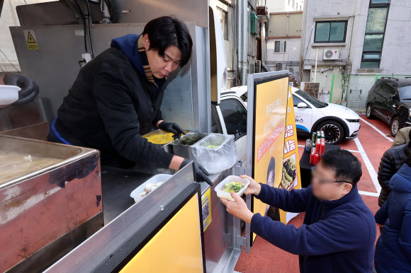 최현석 셰프가 설 연휴 둘째 날인 26일 오전 서울역 쪽방상담소 인근에서 열린 떡국 나눔 푸드트럭 행사에서 쪽방촌 주민들에게 떡국을 나눠주고 있다. 2025.1.26. 연합뉴스