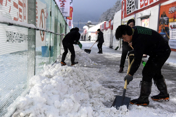 눈이 내린 27일 오전 강원 화천군에서 열리고 있는 산천어축제장에 공무원을 비롯한 축제 관계자와 종사자 등이 관광객 안전을 위한 제설작업을 하고 있다. 2025.1.27 화천군 제공