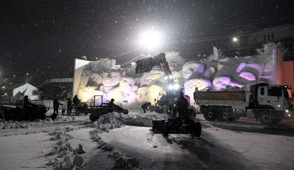 눈이 내린 27일 강원 화천군에서 열리고 있는 산천어축제장에 공무원을 비롯한 축제 관계자와 종사자 등이 관광객 안전을 위한 제설작업을 하고 있다. 2025.1.27  화천군 제공