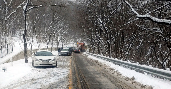 28일 오전 11시 24분께 전북 무주군 설천면 경사로에서 눈길 탓에 차들이 움직이지 못한다는 신고가 119에 접수돼 제설 차량이 이동을 돕고 있다. 2025.1.28. 전북특별자치도소방본부 제공